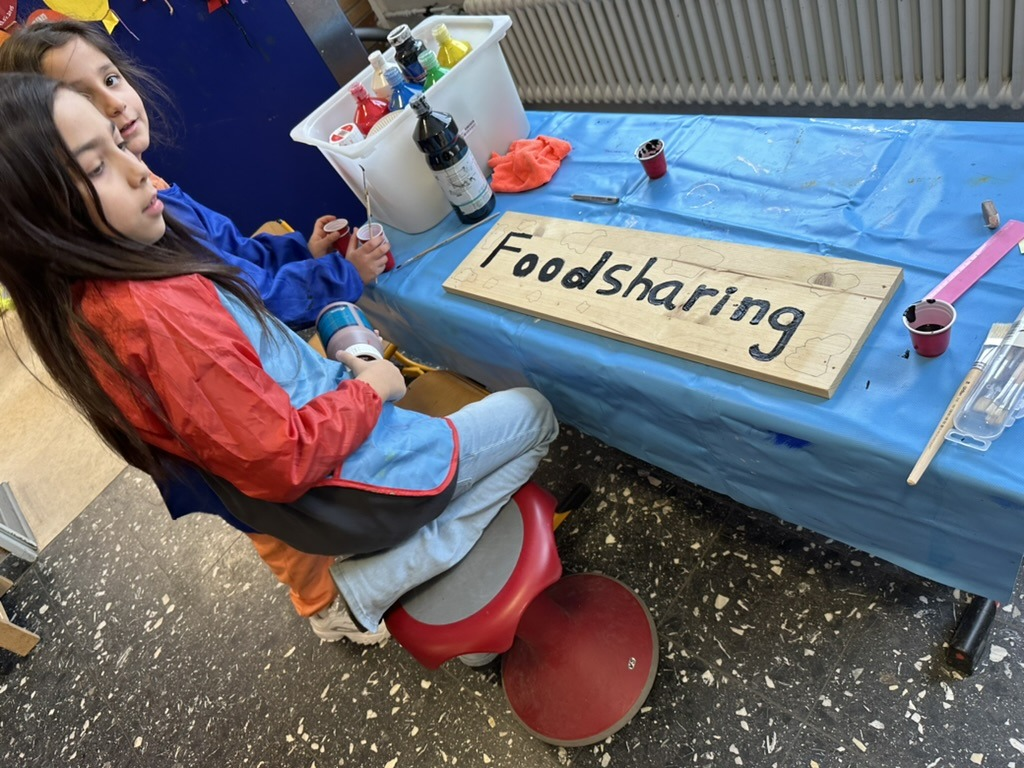 Kinder gestalten ein Schild für ein Foodsharing-Projekt
