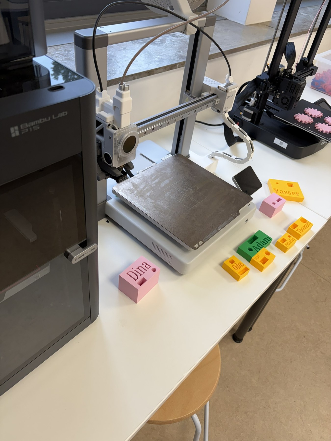 Mehrere 3D-Drucker mit bunten selbst gestalteten Werkstücken
