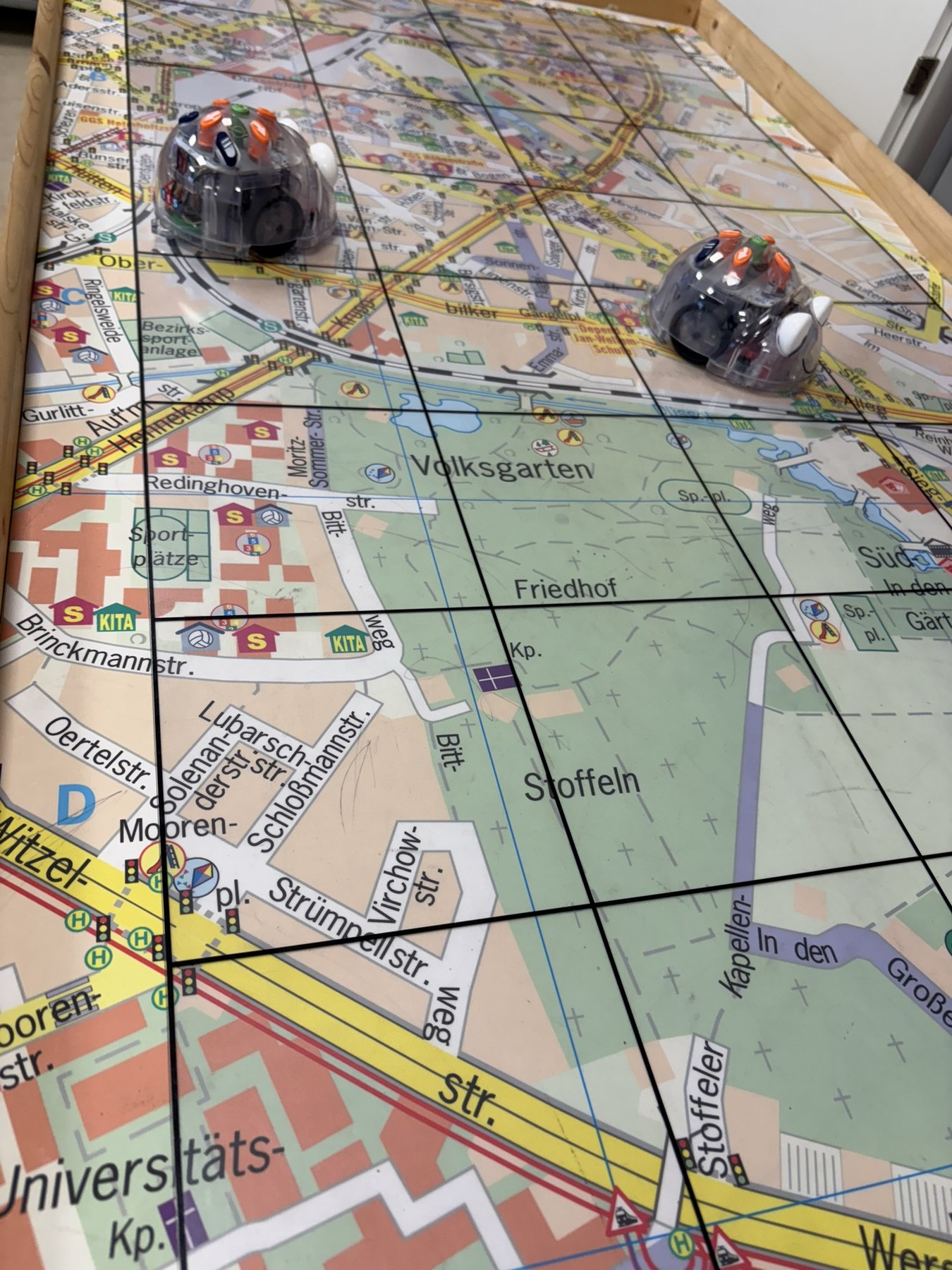 Zwei programmierbare Lernroboter auf einem Stadtplan